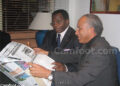 Mustapha Badri présentant son journal au ministre Mbarga Mboa