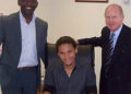 Alex Morfaw (center), with his agent and Iron chairman Steve Wharton, signs for United ahead of the Carling Cup first round clash with Hartlepool United.