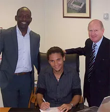 Alex Morfaw (center), with his agent and Iron chairman Steve Wharton, signs for United ahead of the Carling Cup first round clash with Hartlepool United.
